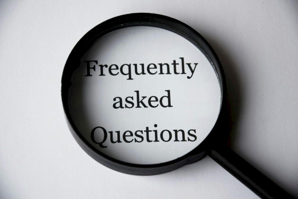 pexels-photo-221164-221164 Close-up of a magnifying glass focusing on the phrase 'Frequently Asked Questions'.